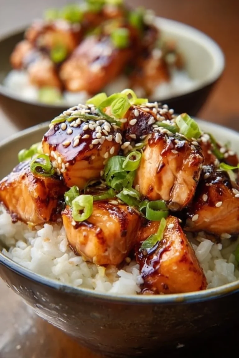 A delicious crispy salmon and rice bowl garnished with vegetables.