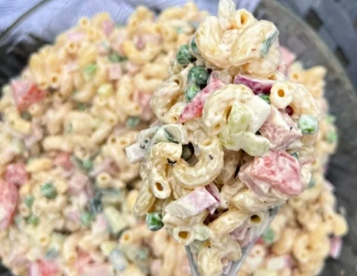 Colorful pasta salad in a bowl with fresh vegetables and dressing